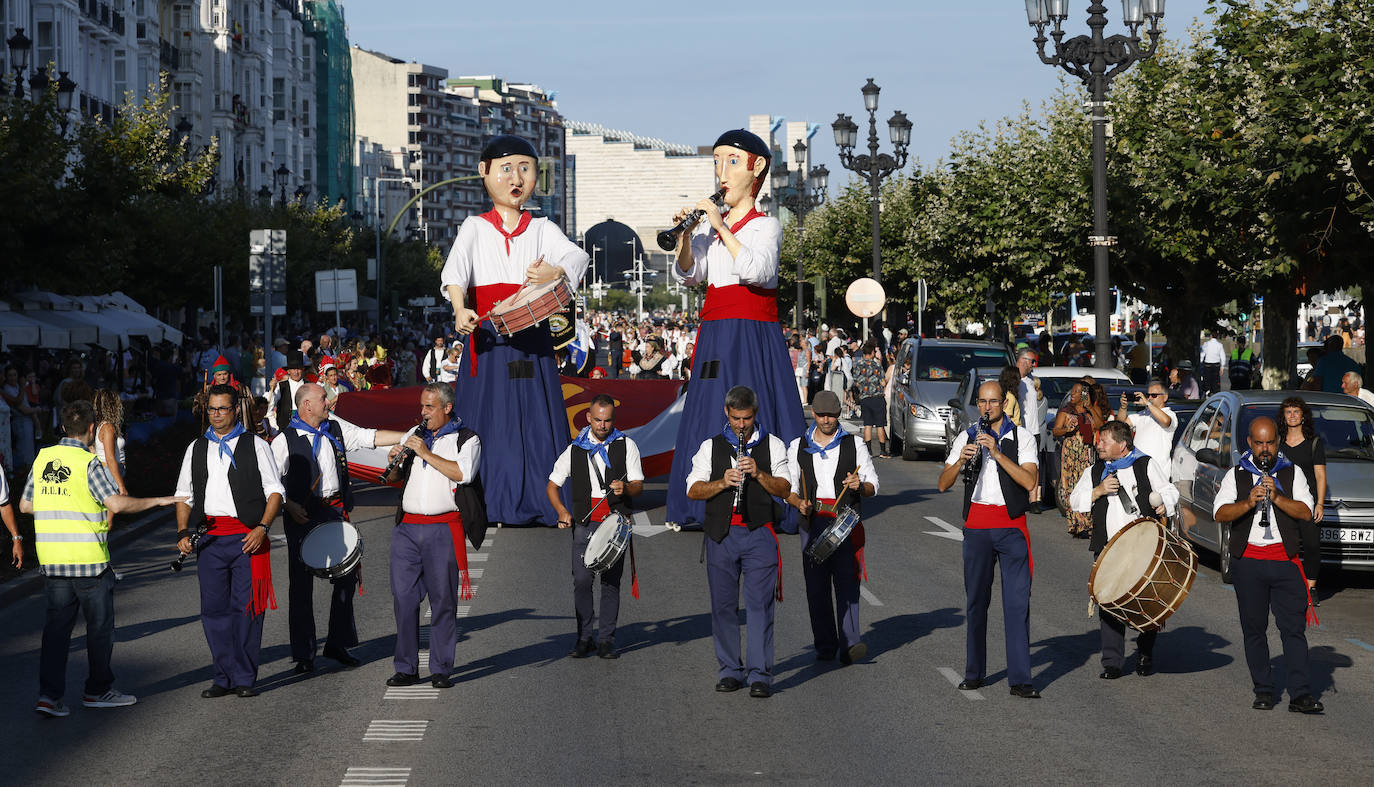 Siete hombres encabezan la IX Edición del Pasacalles cántabro de folclore, acompañados de dos gigantes tocando el tambor y el pito.