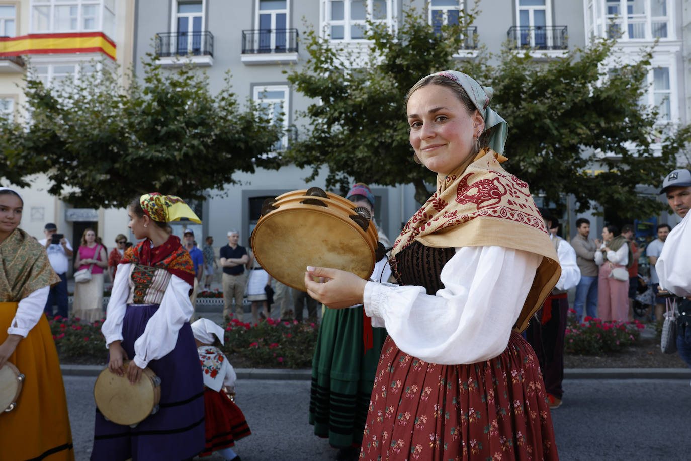 Las mujeres de una agrupación tocan la pandereta.