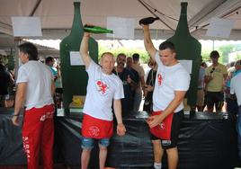 Voluntarios de la Asociación Pomológica de Escalante escanciando la sidra en los vasos.