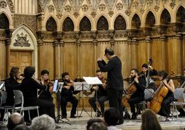 Serguei Mesropian dirige a la nueva orquesta de cámara Oncam Sierra Norte en la iglesia del Seminario Mayor de Comillas.