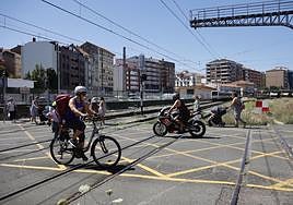 Vecinos cruzan el paso a nivel de Pablo Garnica, junto a la estación de Feve en Torrelavega.