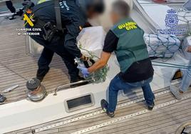 Agentes de la Guardia Civil descargando los fardos de cocaína.