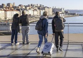 Una pareja de turistas con sus maletas y mochilas por Santander durante sus vacaciones.