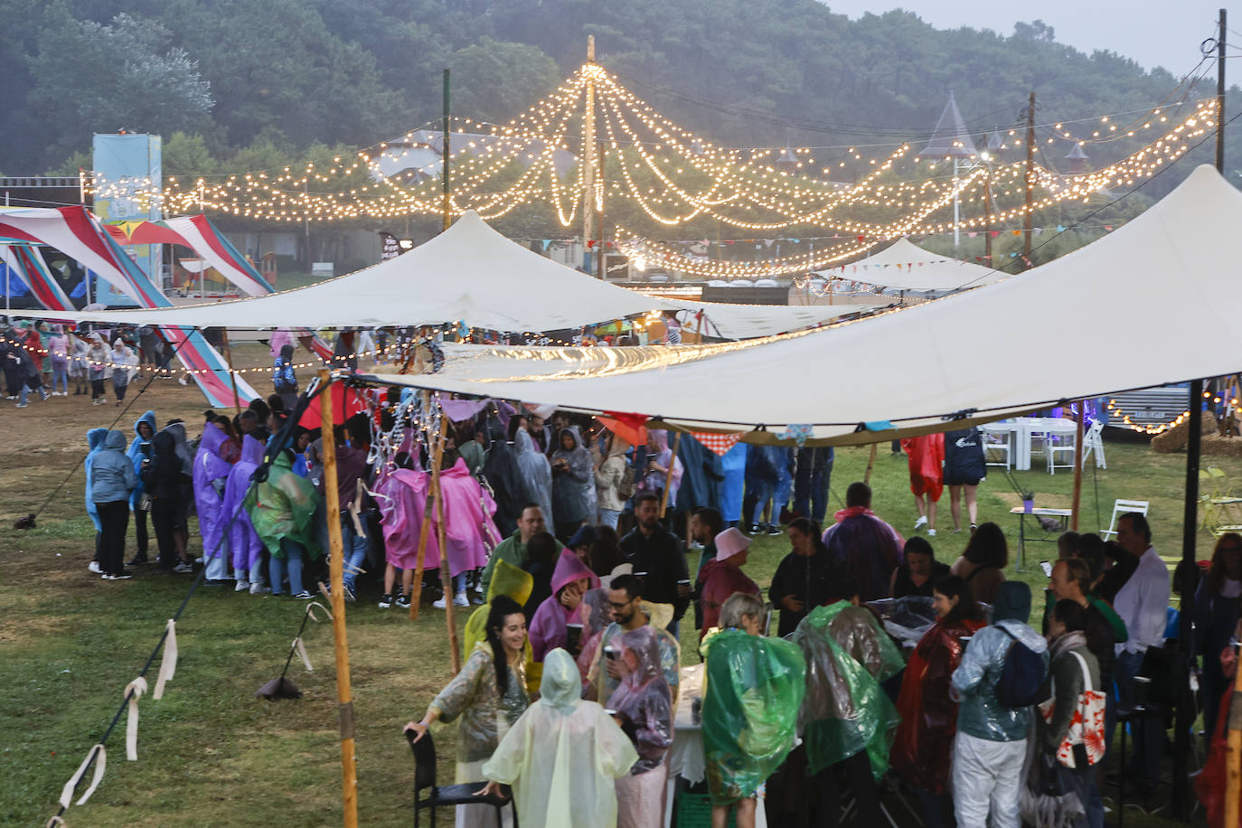 Las carpas de la Campa se llenaron de gente con chubasqueros en busca de refugio.