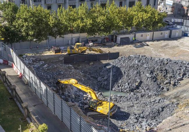 La máquina que excava en una zona de roca, en la que puede verse un charco.