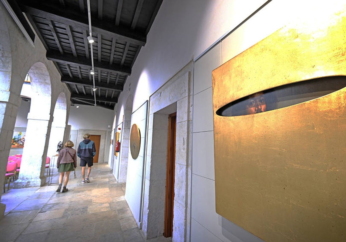 Dos personas visitan la exposición en el patio central del Espolón.
