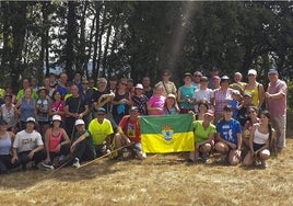 Fátima López, a la derecha, de amarillo, junto a otros participantes con una bandera del municipio.