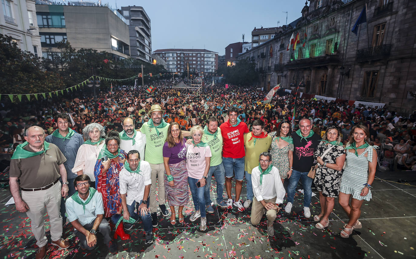 Miembros del equipo de gobierno y la Corporación municipal posan en el escenario del Bulevar, tras el chupinazo y con miles de personas al fondo. 