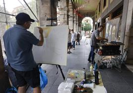 Varios participantes en el certamen se refugian de la lluvia en los soportales de la Plaza Mayor.