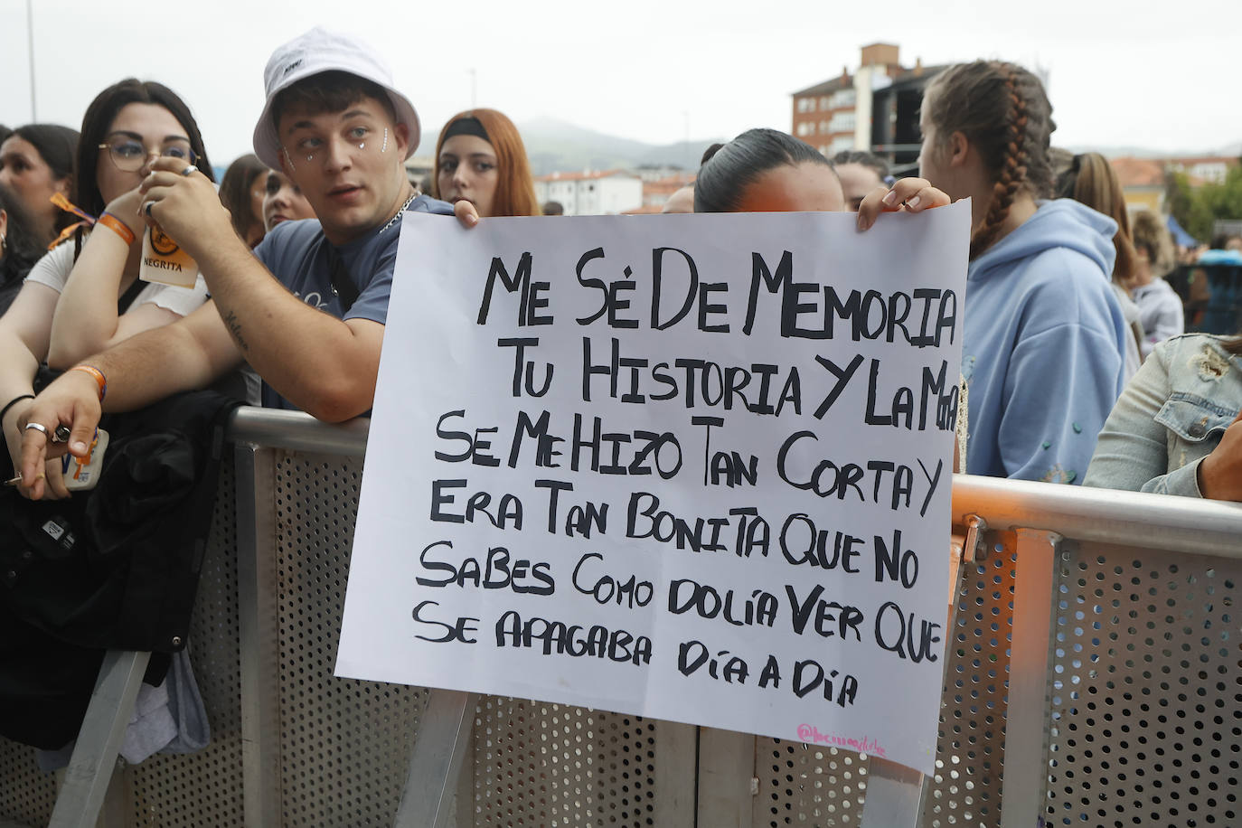 Una asistente muestra un cartel, preparado para uno de los 'shows' del festival de música urbana, este sábado, en La Lechera.