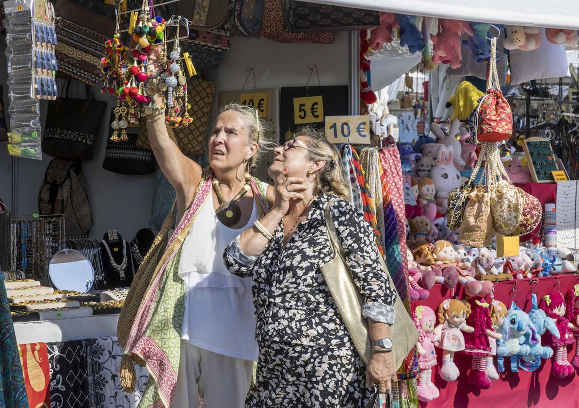 Dos mujeres, este fin de semana, observan los productos de uno de los puestos de artesanía repartidos por el recinto del festival.