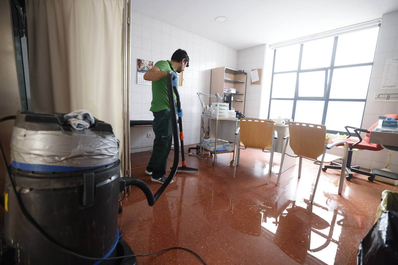 Un operario trata de retirar agua de una de las consultas.