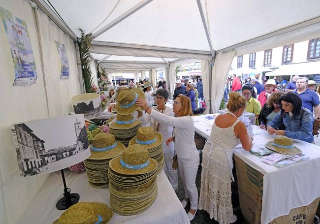 Las organizadoras reparten sombreros de paja y venden las papeletas del sorteo