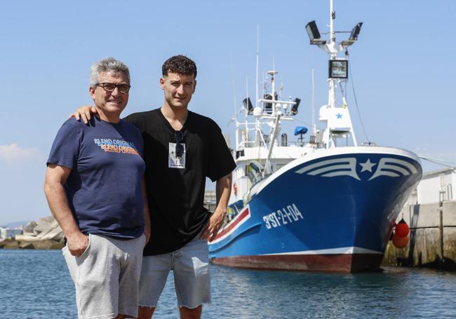 Tonino San Martín, padre e hijo, en el puerto de Laredo con el barco en el que comparten jornadas de trabajo.