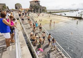 Un grupo de turistas y bañistas en la zona del muelle de Castro Urdiales.