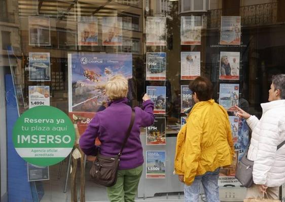 Un grupo de mujeres comenta la oferta de viajes del Imserso.