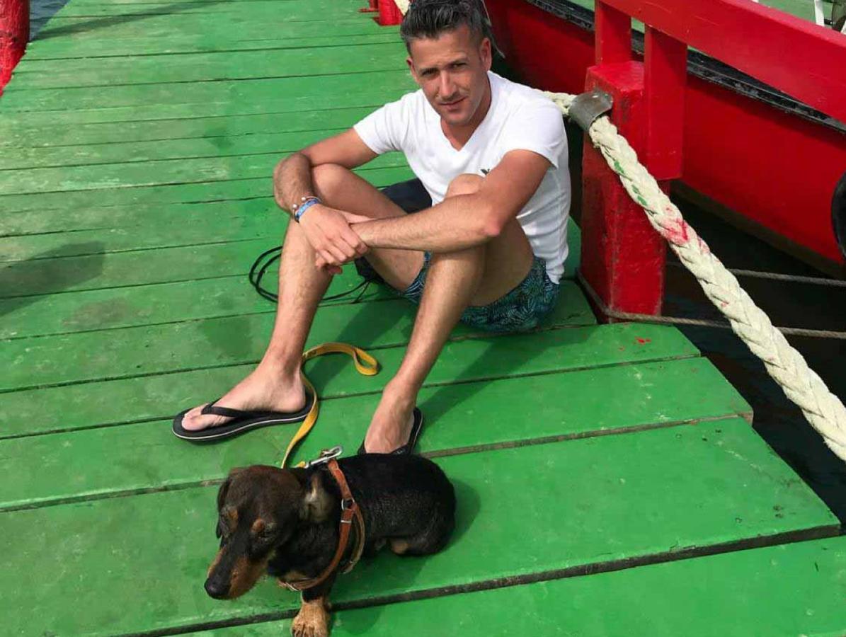 tJorge Mena, junto a su perro Nico, en el embarcadero de la playa de El Puntal.