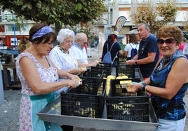 Desde las nueve de la mañana los vecinos colaboran en la trisca de patatas  en la plaza de San Antonio