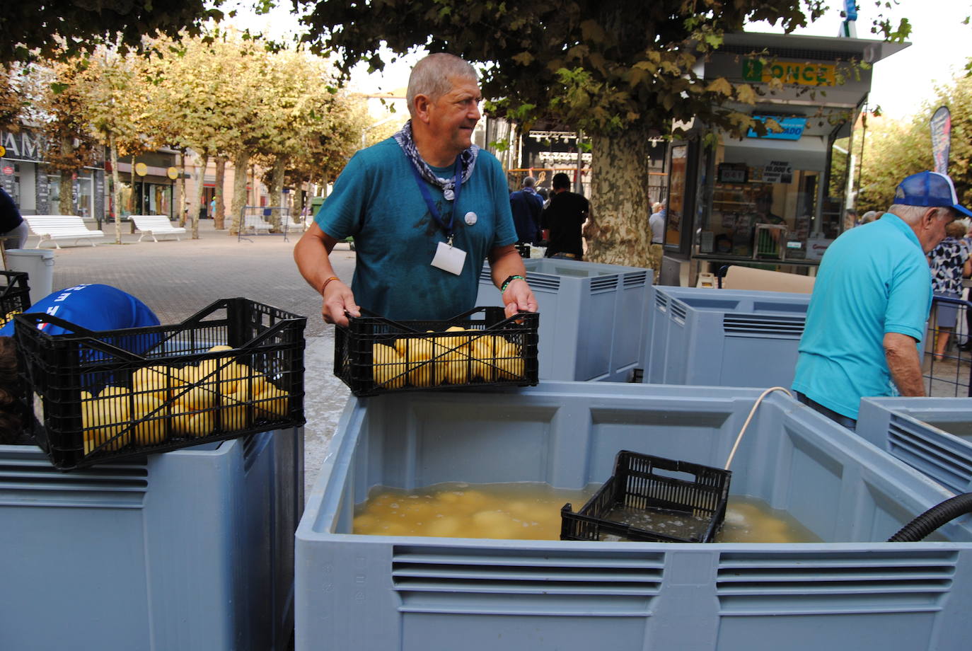 César Ortiz,  integrantes de la organización, saca una caja con patatas del cubo donde están almacenadas con agua 