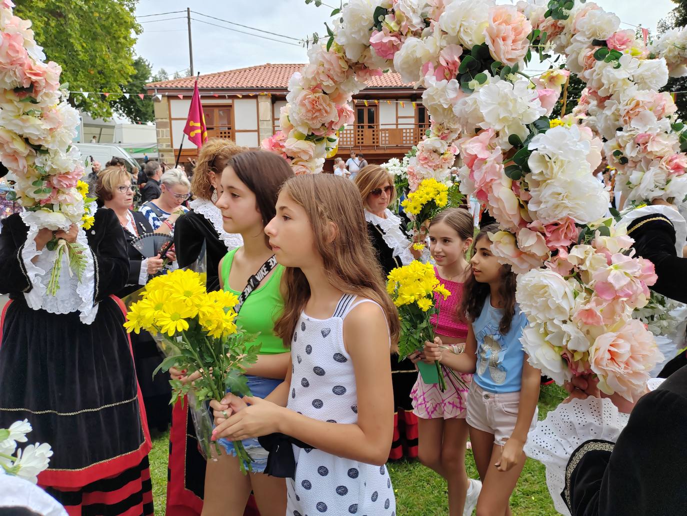 La Virgen de Valencia recibe sus flores por parte de los asistentes que cruzan el arco floral