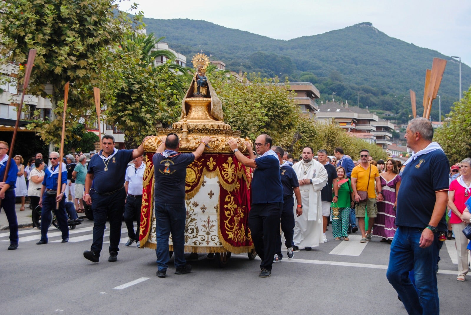 Decenas de vecinos acompañaron a la Virgen en su paseo por tierra y otros tanto se apostaron en las aceras para contemplarla. 