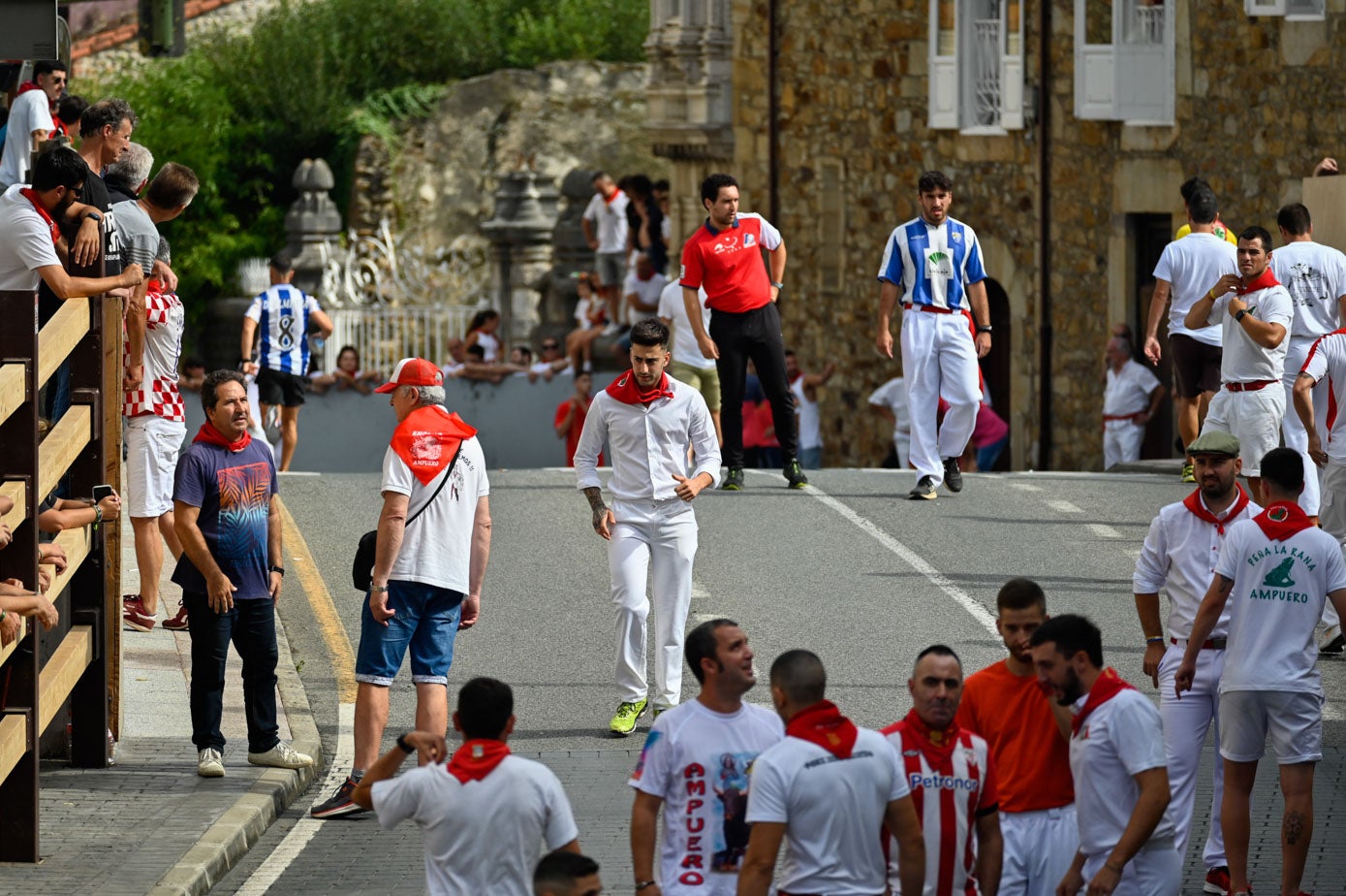 Los corredores inspeccionan el camino antes de que salgan los toros.