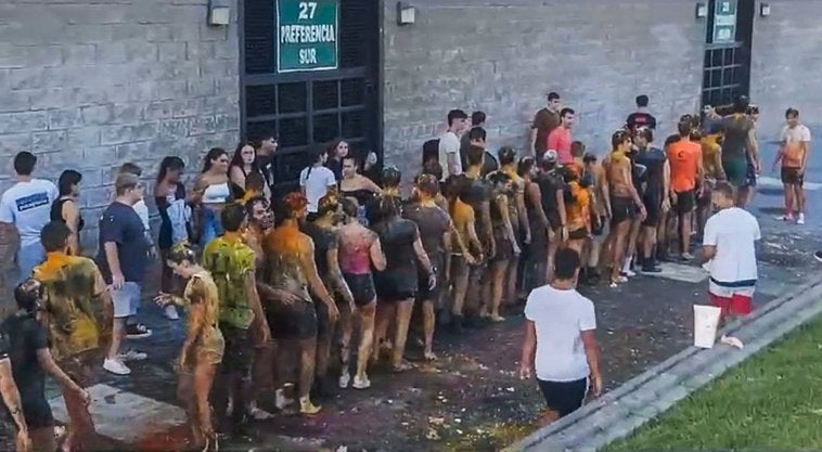 Los estudiantes de primer curso, en fila india, empapados y manchados, a las órdenes de los veteranos, el pasado miércoles, en El Sardinero.