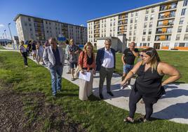 Una vecina muestra al consejero de Fomento, Roberto Media, desperfectos en el parque de Nueva Montaña que se derrumbó.