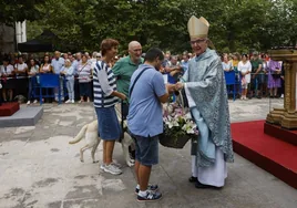 El obispo, Manuel Sánchez Monje, recibe una ofrenda floral para la Virgen Bien Aparecida.