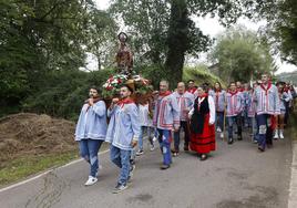 Los romeros portan la imagen del santo camino de la emita de La Pradera