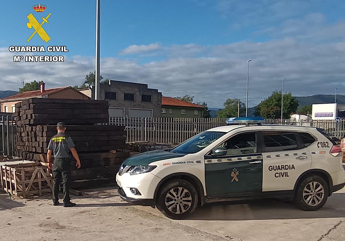 Un Guardia Civil observa traviesas de madera almacenadas en la empresa en la que se produjo el robo.