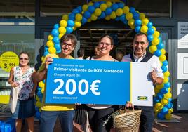 David Cajal y Nurettin Acar, de Ikea, entregan a Isabel Gómez un cheque regalo de 200 euros por ser la primera clienta en entrar a la tienda
