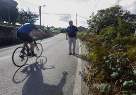 Pepe Abascal se cruza con un ciclista mientras camina por la carretera de La Montaña.