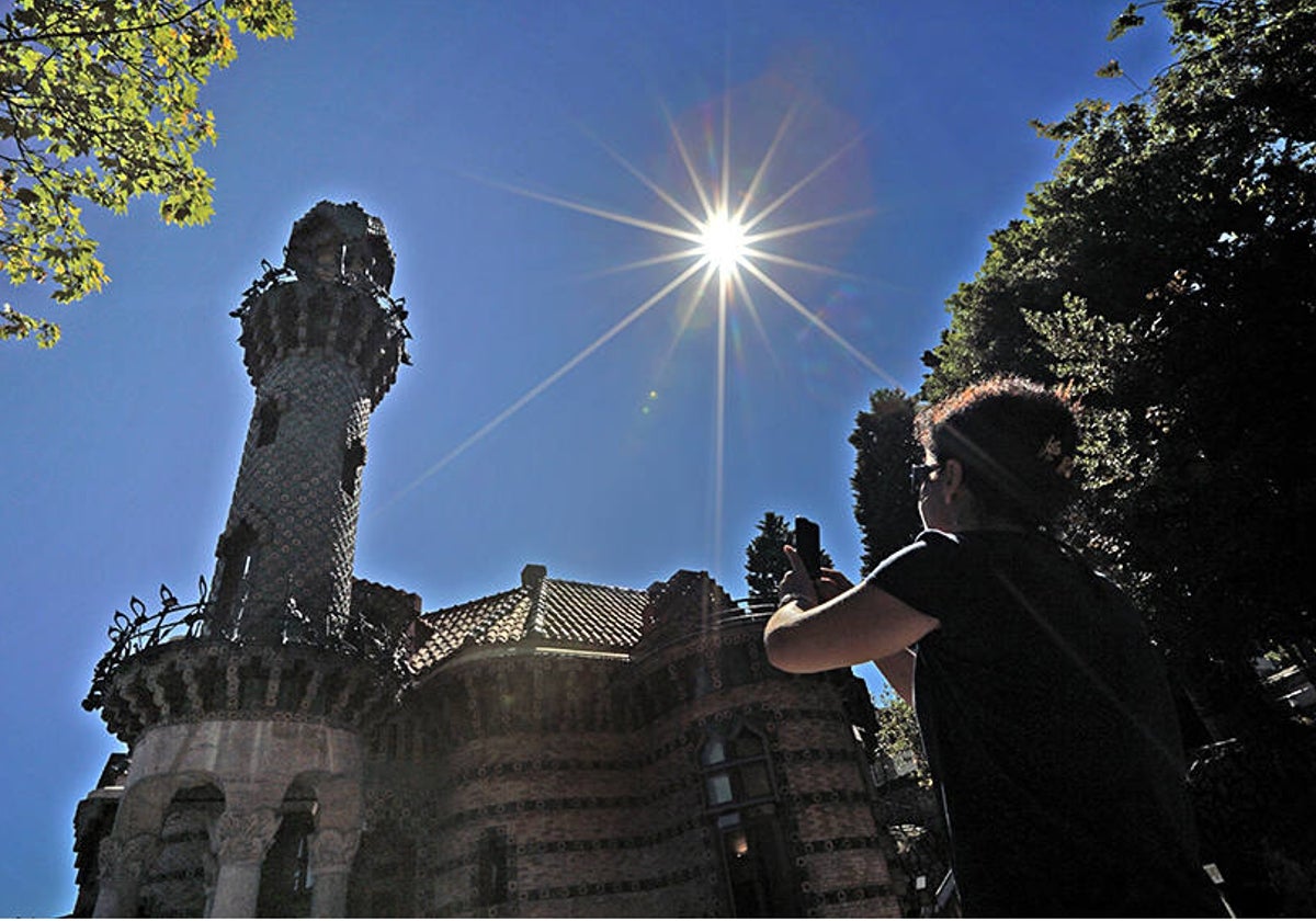 Una visitante realiza una foto del edificio a pleno sol.