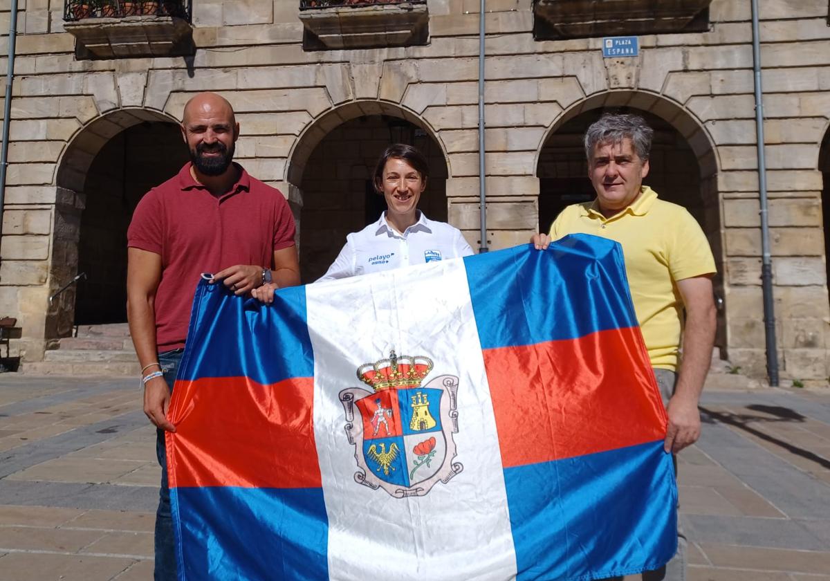 El alcalde de Reinosa, José Luis López Vielba (derecha), y el concejal de Deportes, Daniel Santos (izquierda) han entregado este martes una bandera de Reinosa a Sonia Saiz.