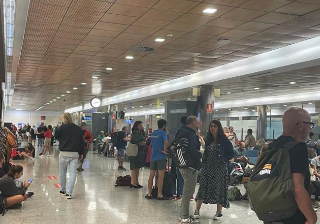 Los pasajeros esperan en el aeropuerto soluciones para sus vuelos retrasados.