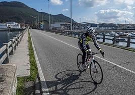 Un ciclista circulando por el tramo de Santoña de la carretera de los puentes.