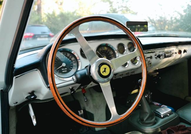 Detalle del interior del Ferrari, con su volante de madera.