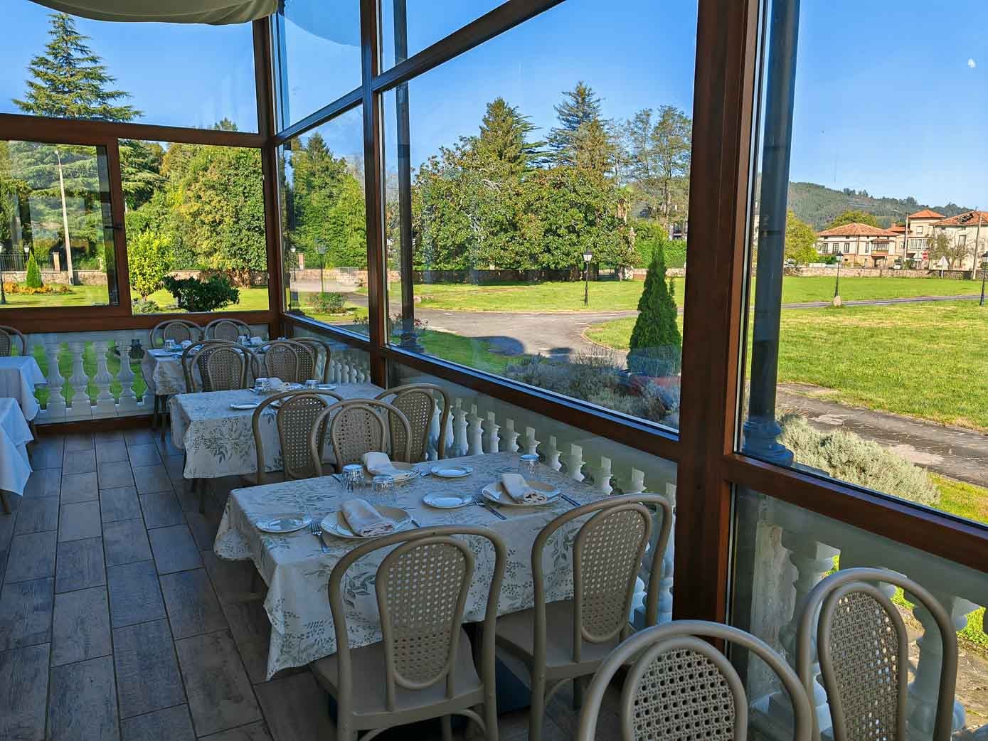 Terraza acristalada, con las mesas de comer ya puestas para el servicio.