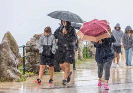 Turistas sorprendidos por un chaparrón en el recinto del Palacio de la Magdalena.