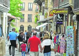 Una de las calles del casco urbano de Comillas llena de personas en una tarde de verano.