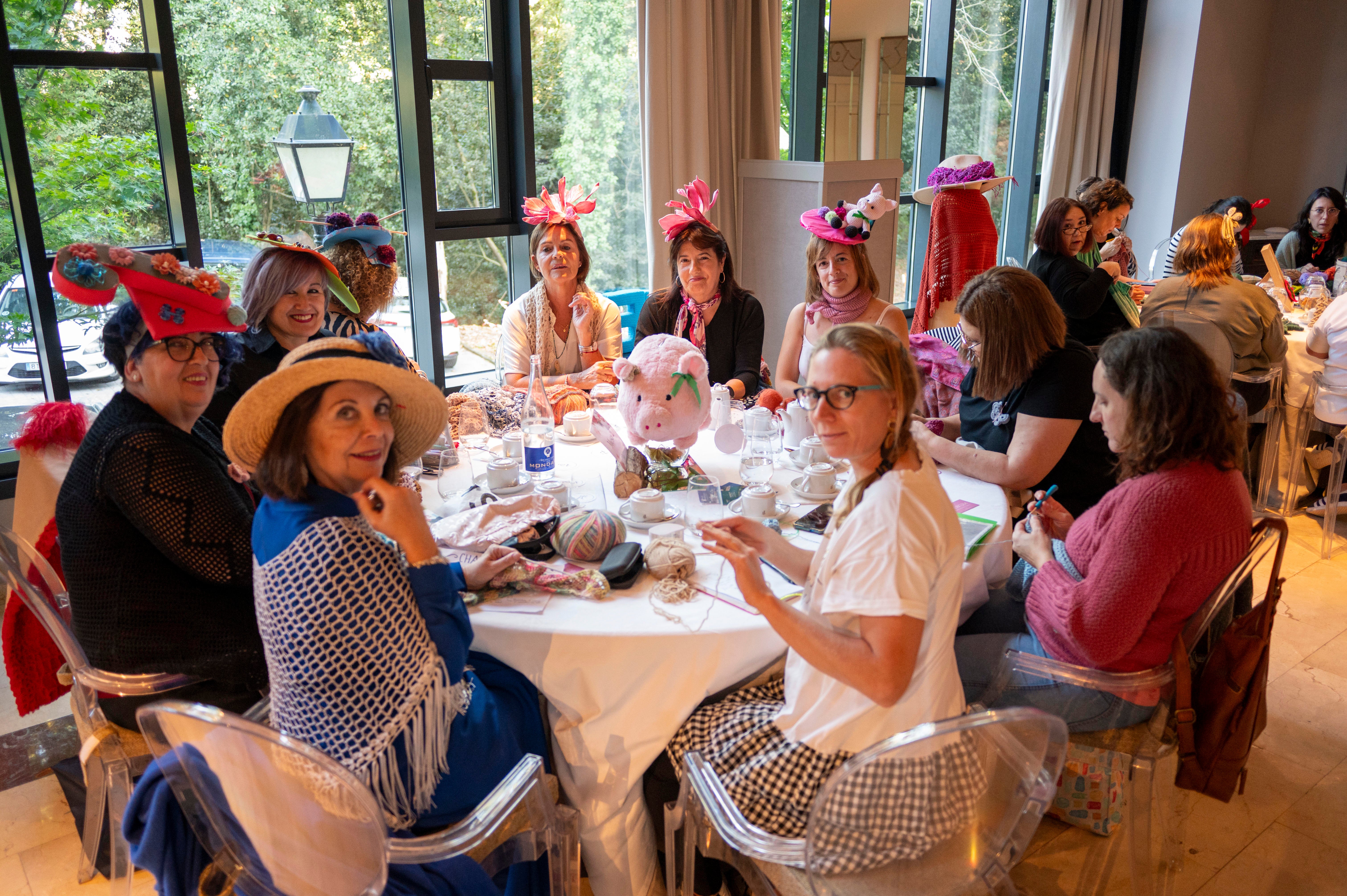 Algunas mujeres enseñan los curiosos sombreros que han confeccionado.