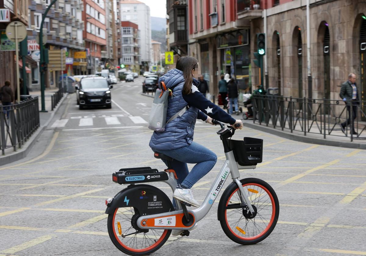 Una joven cruza Cuatro Caminos con una bicicleta eléctrica de Torrebici.