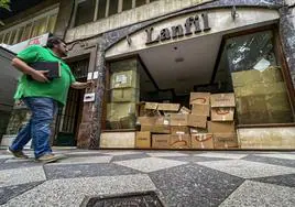 El escaparate de la tienda Confecciones Lanfil, que está cerrada, lleno de cajas de cartón