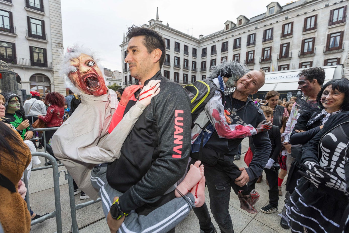 Dos amigos disfrazados con sendos zombis, en la cola del pasaje del terror, 'La Perla'.