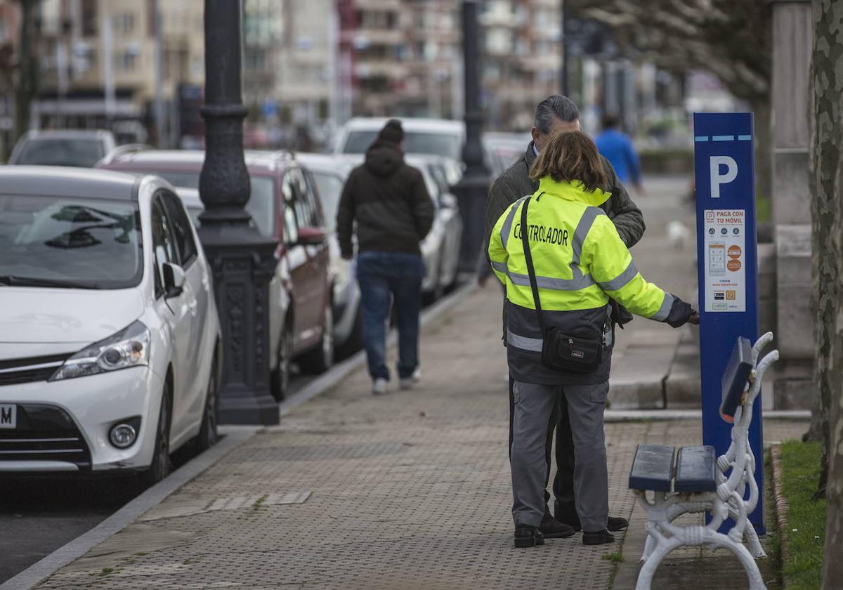 Una controladora de la OLA junto a un parquímetro.