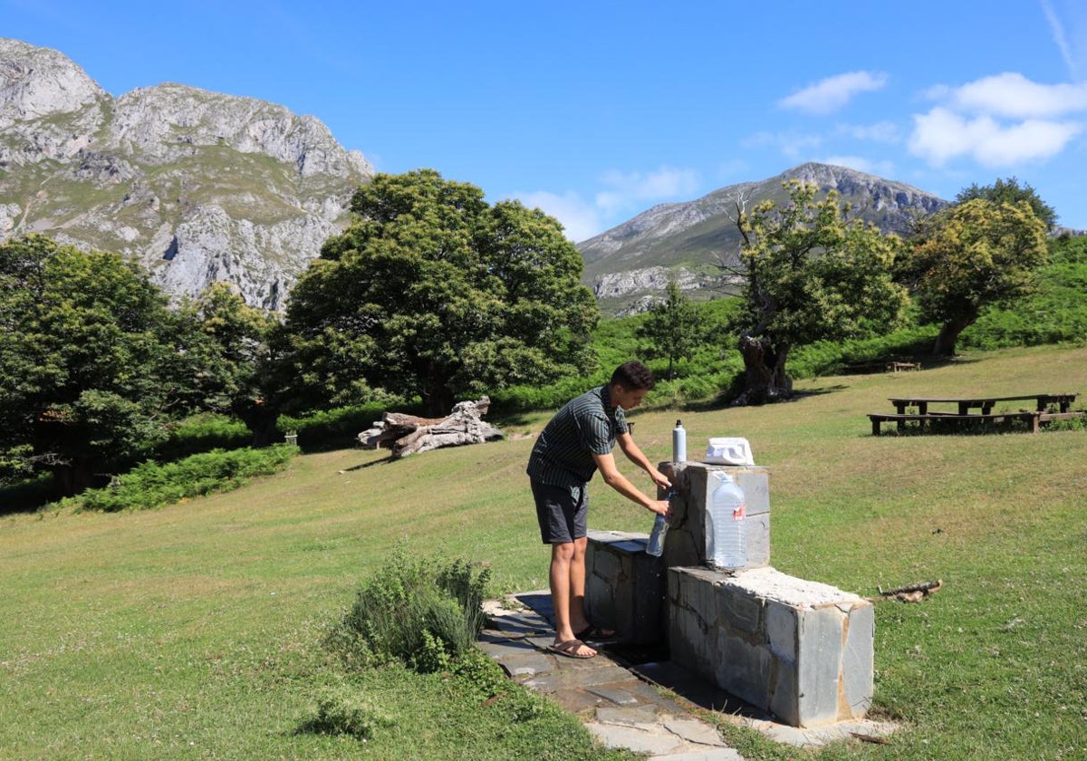 Un peregrino recoge agua en la fuente de El Habario (Pendes)