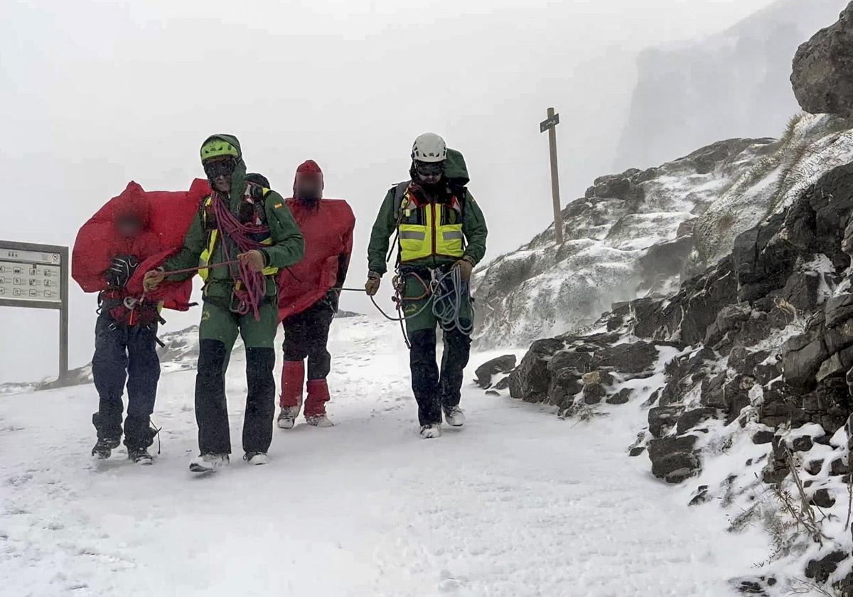 Agentes del Greim con los dos montañeros rescatados.