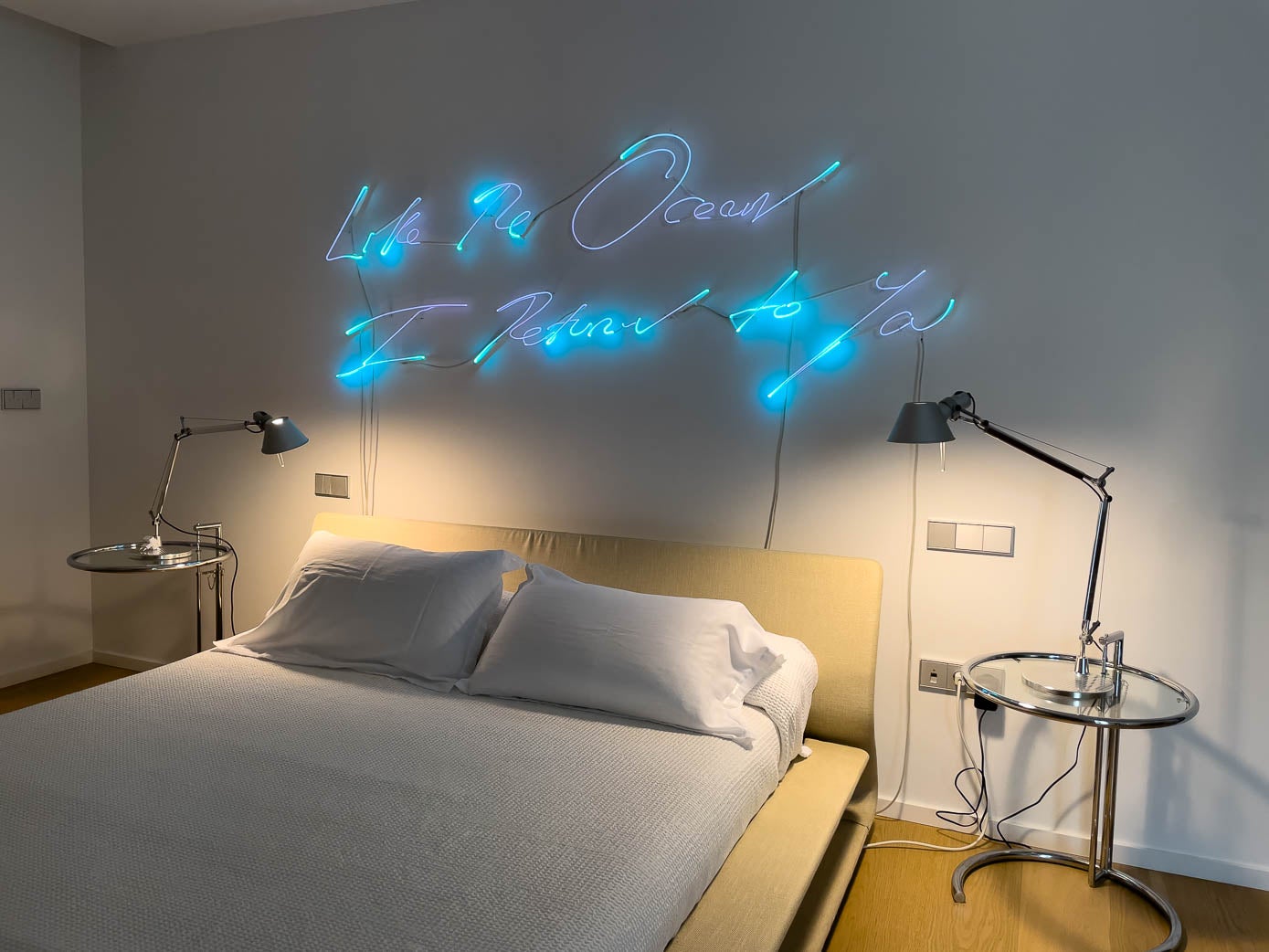 Zona de dormir del cuarto principal, con una obra luminosa de la artista británica Tracey Emin.