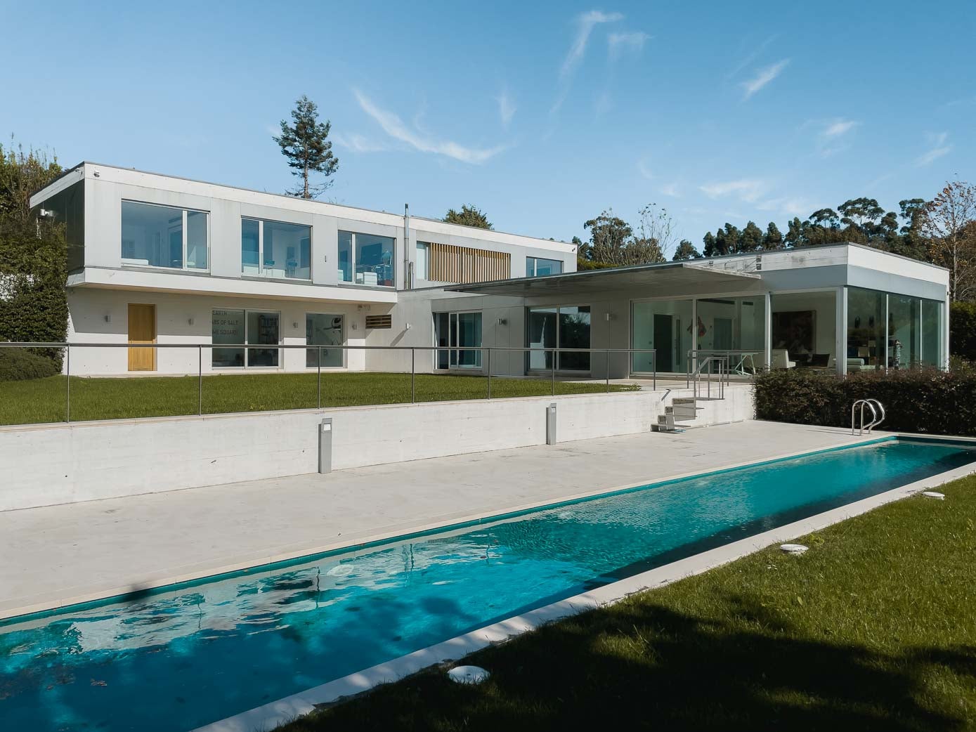 Fachada de la vivienda, con estructura en 'L', y la piscina.